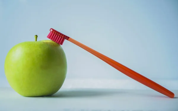 Manzana Verde Con Cepillo Dientes Rojo Aislado Sobre Fondo Azul —  Fotos de Stock