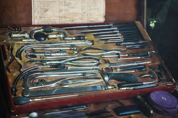 set of vintage medical surgical instruments in  red box.