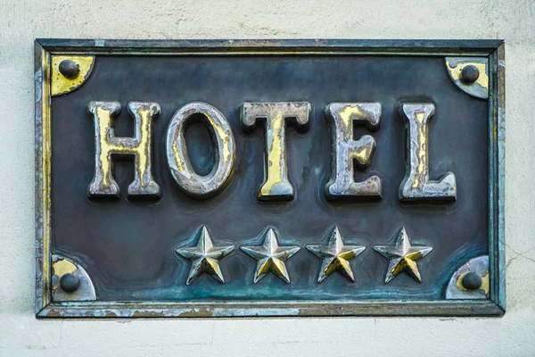 ゴールデンボードや4つ星ホテルの看板 4つ星ホテルの看板 星の宣言があるホテルの看板のある建物の壁 — ストック写真