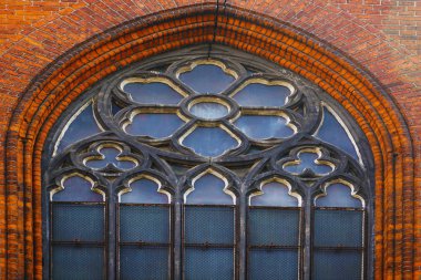 Big round church window with floral frame decoration.Round stone window on a church wall               