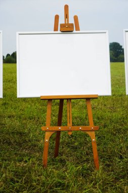 Bahçede boş şöne şablonu. Şelat, yeşil çimenlerle sahada durarak resim yapmaya hazır. boş çerçeve arka plan. 