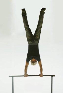 Mavi gökyüzü arka plan üzerinde yatay çubuk üzerinde pull-up yapma Kas adam. arka görünüm. 