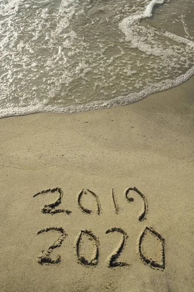 Happy new year 2019 -  2020 number written on sand. Top view. Happy new year concept, 2019 writing on sand beach. next 2020