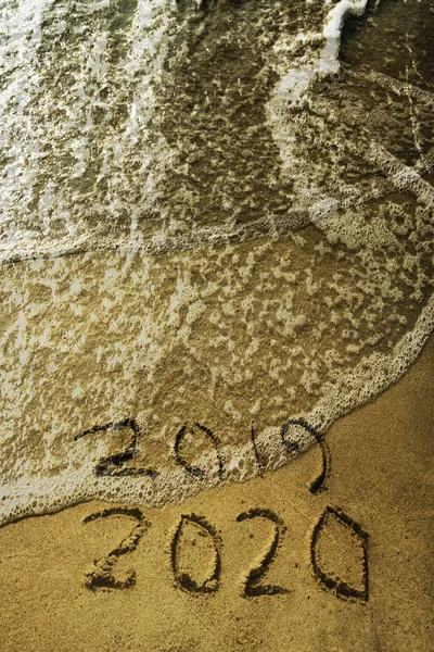 Happy new year 2019 -  2020 number written on sand. Top view. Happy new year concept, 2019 writing on sand beach. next 2020