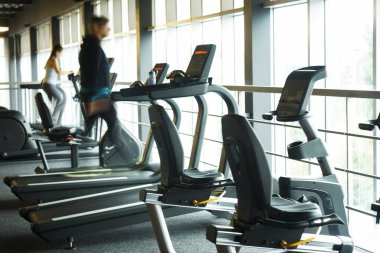 Spor salonundaki bulanık arka plan izleme makineleri. Ön tarafta çalışan sayaç ve arka planda bulanık çalışan insanlar, fitness merkezinin konsepti.