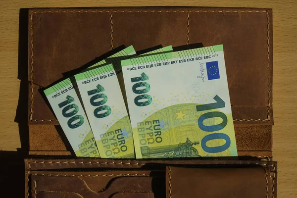 用100欧元钞票打开钱包 棕色的真正的男性钱包 木制背景 — 图库照片
