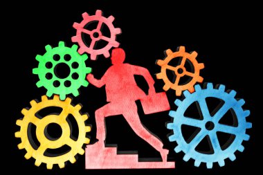 Davası olan işadamı, siyah arka planda izole edilmiş dişli çarklar ve dişli çarklar kullanıyor.. 