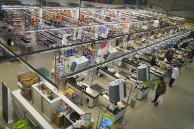 Kaliningrad, Rusya-18 Eylül 2019: Büyük Süper Merkez 'de satın alınan malları bekleyen insanlar. Dükkan sahibi kasadaki ürünlerin parasını ödüyor. Süpermarkette konveyör bandındaki yiyecekler