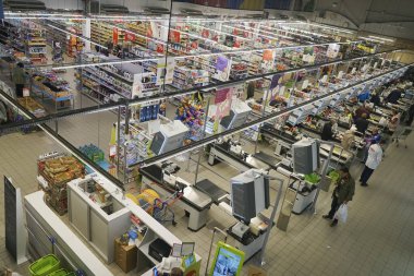 KALININGRAD, RUSSIA-18 SEPTEMBER 2019: People waiting  for the purchased goods at the Big  Super center. Shopper paying for products at checkout. Foods on conveyor belt at the supermarket clipart