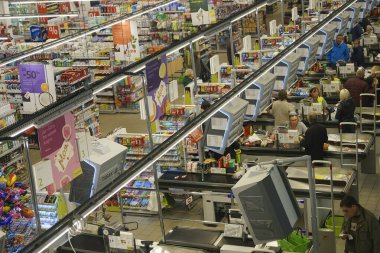 Kaliningrad, Rusya-18 Eylül 2019: Büyük Süper Merkez 'de satın alınan malları bekleyen insanlar. Dükkan sahibi kasadaki ürünlerin parasını ödüyor. Süpermarkette konveyör bandındaki yiyecekler
