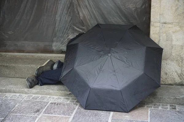 工作少 无家可归的欧洲男人在黑色湿雨伞下在雨中 — 图库照片