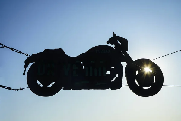 A silhouette of a chopper motorcycle from a side view. Background of vintage motorcycle in silhouette scene