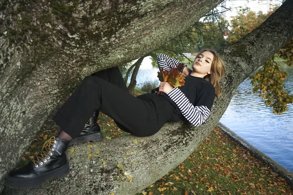 Belle jeune fille adulte porter robe noire et se détendre sur l'arbre tr — Photo