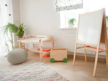 Taburesi ve resim masası olan anaokulu odası. Çocuk odası ve mobilya 