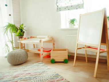 Taburesi ve resim masası olan anaokulu odası. Çocuk odası ve mobilya 