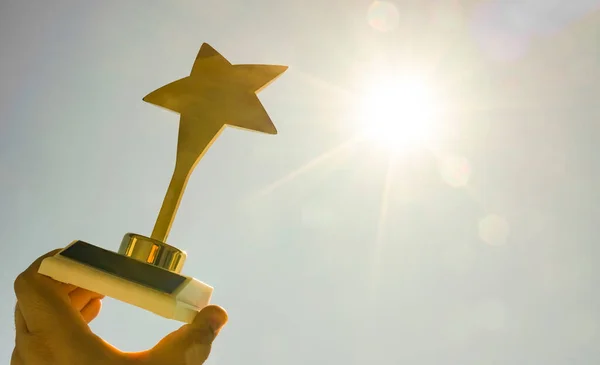 Prêmio Estrela Ouro Mão Masculina Fundo Azul Céu Ensolarado Luz — Fotografia de Stock