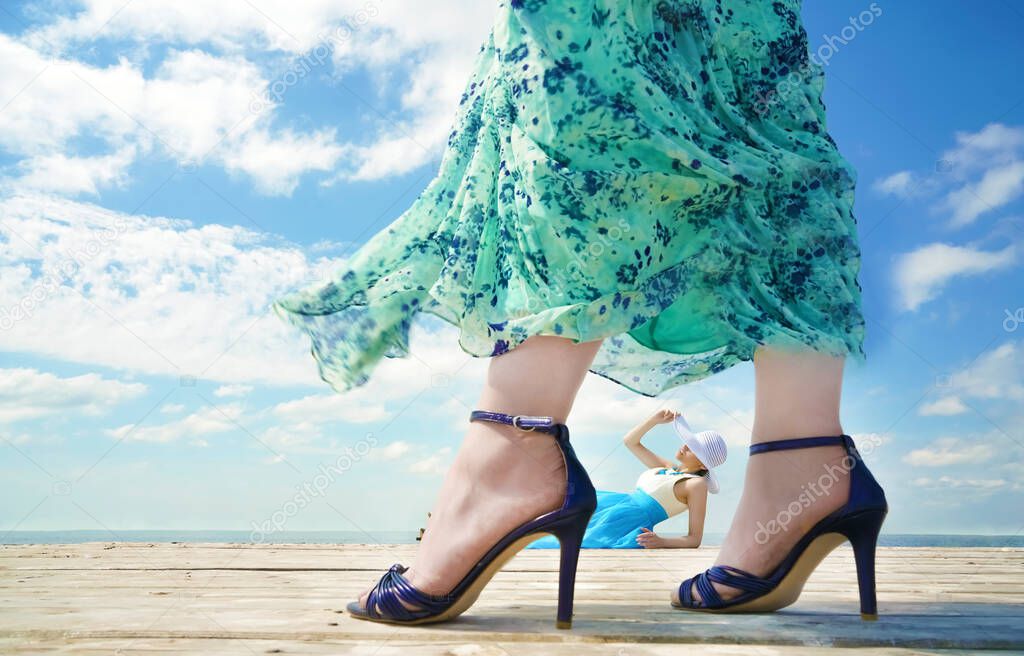 Beutiful young lady relax and enjoy summer at the seaside. other woman wearing high hills bliue shoes. beauty, fashion.