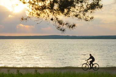 Akşamın renkli gündoğumu sırasında siluet bisiklet. Güzel güneş manzaralı siluet bisiklet. 