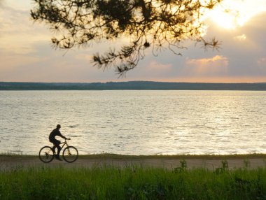 Akşamın renkli gündoğumu sırasında siluet bisiklet. Güzel güneş manzaralı siluet bisiklet. 