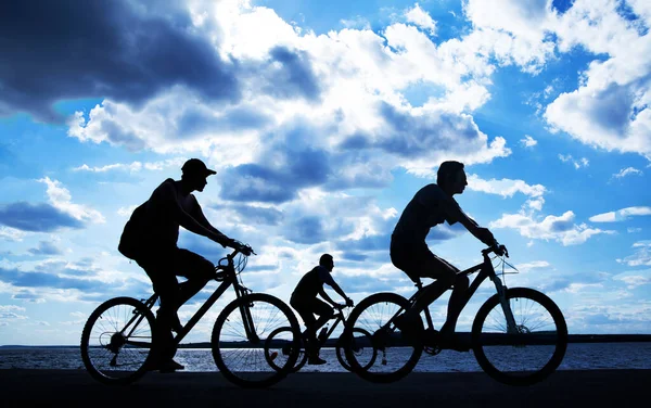 空荡荡的地方日落时骑自行车的朋友们 骑自行车的人沿着海岸骑行 大自然体育背景 — 图库照片