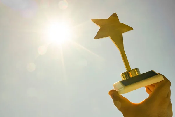 Prêmio Estrela Ouro Mão Masculina Fundo Azul Céu Ensolarado Luz — Fotografia de Stock