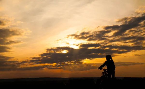 Mittle女孩和自行车的轮廓 健康的生活方式 日落时骑婴儿车的人 女性望着日落的地平线 后视镜 — 图库照片