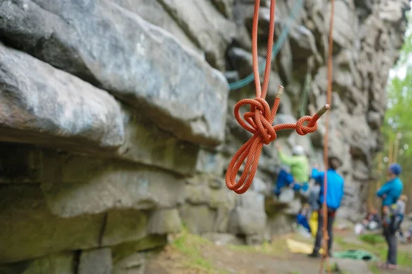 focus on red rope. Climber hanging on a safety rope. Climbing tools hanging on the climber