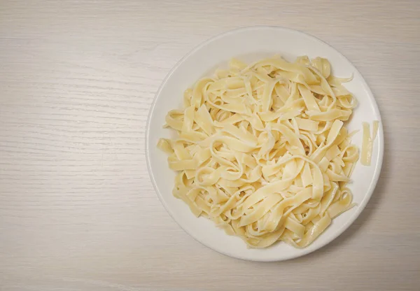 Pasta after been  boiled, spaghetti pasta in white dish for cooking on wooden background.