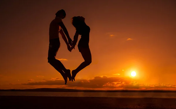 Silhouette Young Barefoot Couple Jumps Sunset Beach Water Texture Orange — Stock Photo, Image