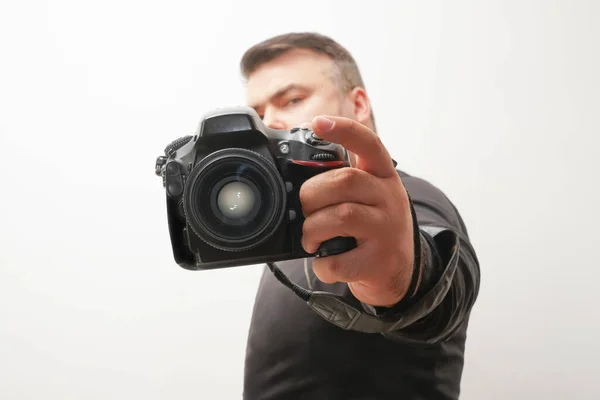 photographer taking a photo with digital 50mm lens reflex camera.Man taking photo of you with mirror camera. photographer with lens in hand on blue background. close-up camera.focus on lens