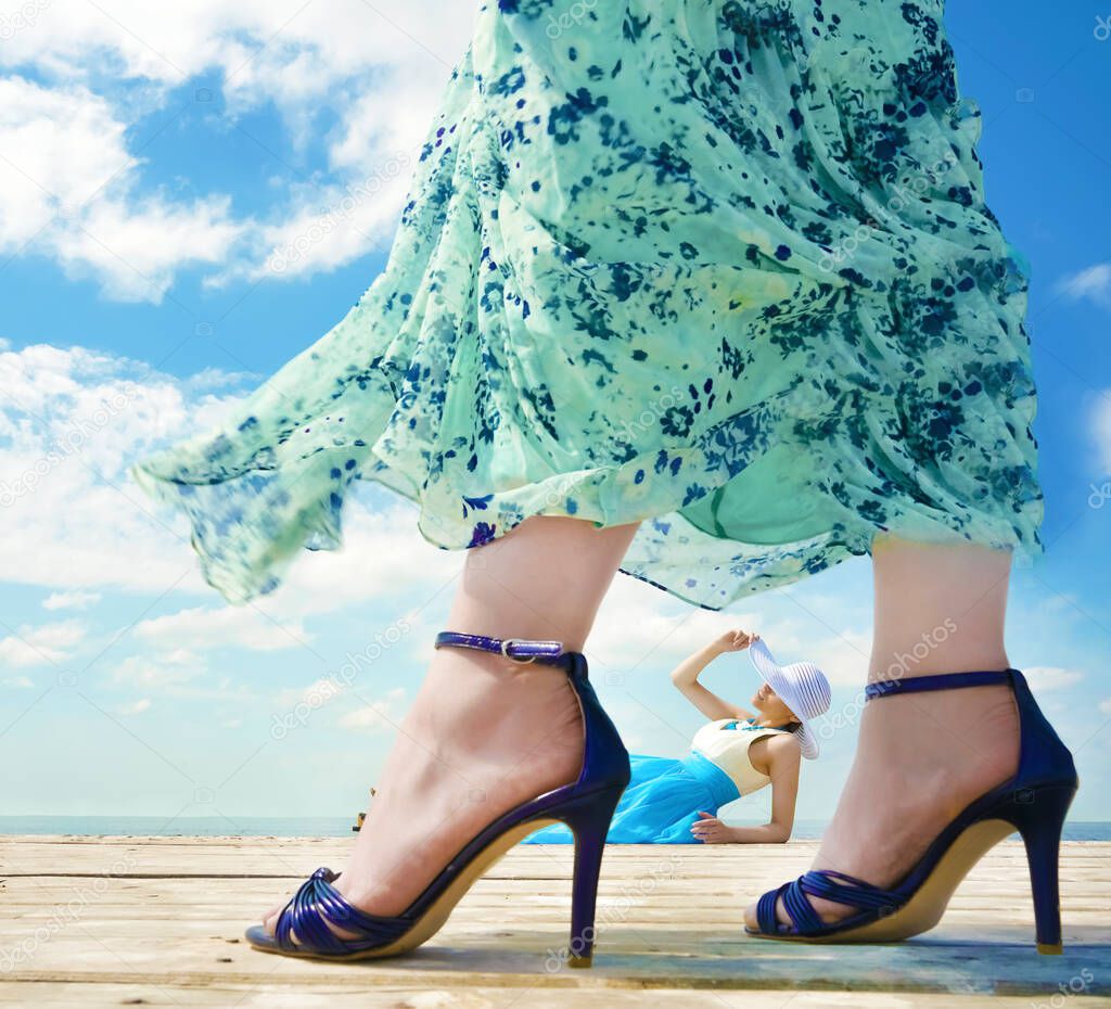 Beutiful young lady relax and enjoy summer at the seaside. other woman wearing high hills shoes. beauty, fashion .