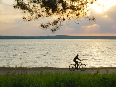 Akşamın renkli gündoğumu sırasında siluet bisiklet. Güzel güneş manzaralı siluet bisiklet arka plan kavramları, uygun motorcu duvar kağıdı, çevresel duygu