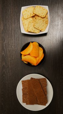 Üç tabak kraker, çıtır kraker, tuzlu cips. Üst Manzara. yiyecek arka planı.