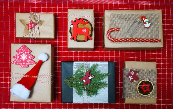 Noel Kompozisyonu Çam Dalları Hediye Kutuları Tahta Geyikler Kırmızı Masa — Stok fotoğraf