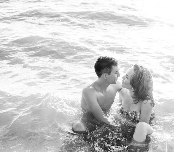 Sexy kiss in hot water. passionate couple in sitting in sunset sea shore or ocean. perfect body and sporty couple. man and woman outdoors. empty copy space for inscription. couple in love. summertime season