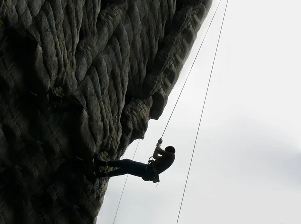 Silhouette Scalatore Una Scogliera Sopra Montagna Sport Estremi Uomo Arrampicata — Foto Stock