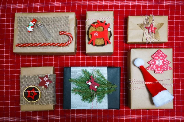 Noel Kompozisyonu Çam Dalları Hediye Kutuları Tahta Geyikler Kırmızı Masa — Stok fotoğraf