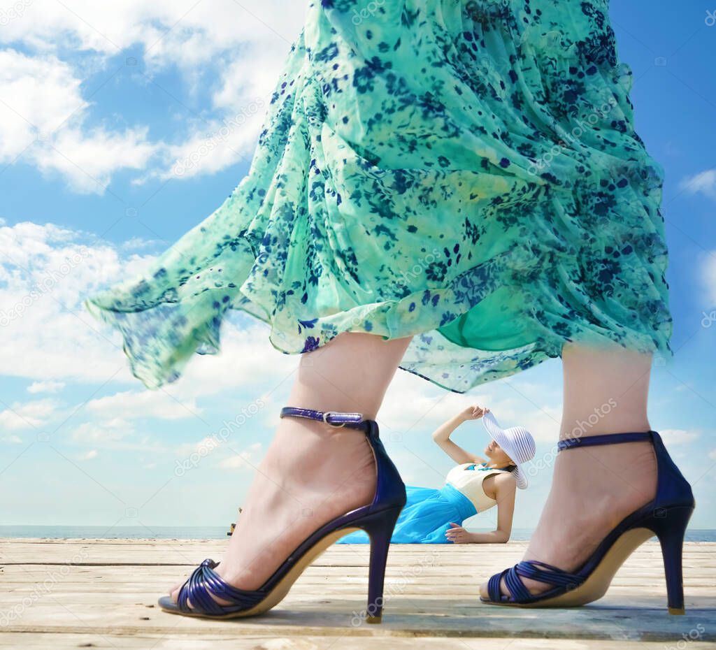 Beutiful young lady relax and enjoy summer at the seaside. other woman wearing high hills shoes. beauty, fashion .
