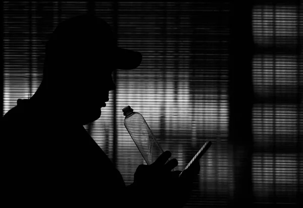 Silhouette Homme Buvant Dans Une Bouteille Plastique Tournée Contre Verre — Photo