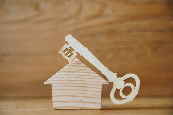 home key  on roof of wooden house. wood  background.  home sweet home concept, empty copy space