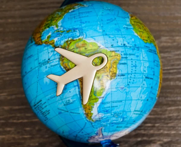 Travel with plane, small toy plain on globe map background, traveling and logistic  concept