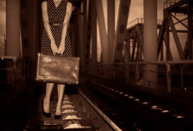 Demiryollarında bavuluyla yalnız genç, sıska bir kız. Yüzü yok. Gece sahnesi. Bir kadın ve eski bir dava demiryolu köprüsünde. Gezgin fikri.