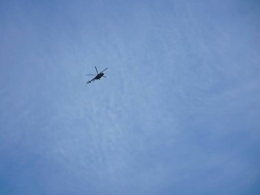 O zamanki İngiliz kırsalında bulutlu havada uçan İngiliz askeri helikopterinin gölgeli bir fotoğrafı.