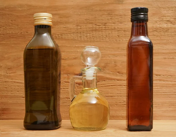 三个不同的橄榄油玻璃透明瓶的背面 软木塞立在木板上 厨房空间房间 供登记用的空空间 — 图库照片