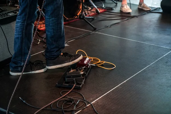 ギターを弾く スタジオでね リハーサルでね 効果ペダル 足の下に歪み効果ペダルをセットしたステージ上のエレクトリックベースギタープレーヤー — ストック写真