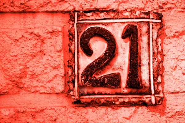 Number 21, twenty one, decorative tile with black digit on white wall background.