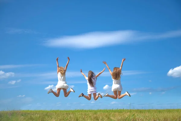Drie Lachende Meisjes Springen Het Veld — Stockfoto
