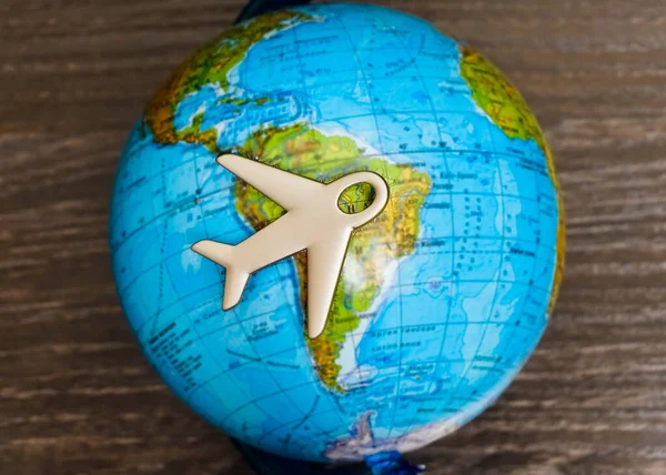 Travel with plane, small toy plain on globe map background, traveling and logistic  concept