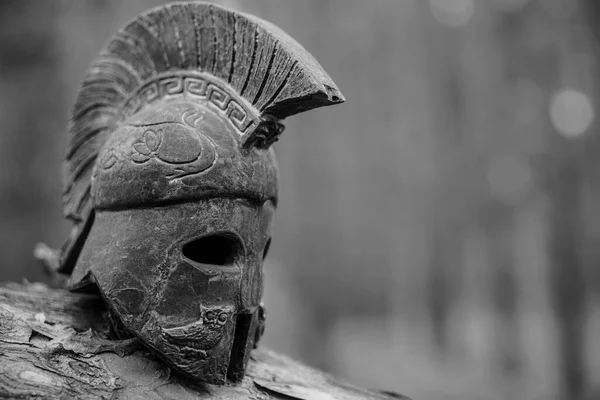 松林の背景に歴史的なレプリカスパルタン戦士ヘルメット 小さなミニチュアローマのヘルメットのビューを閉じます — ストック写真