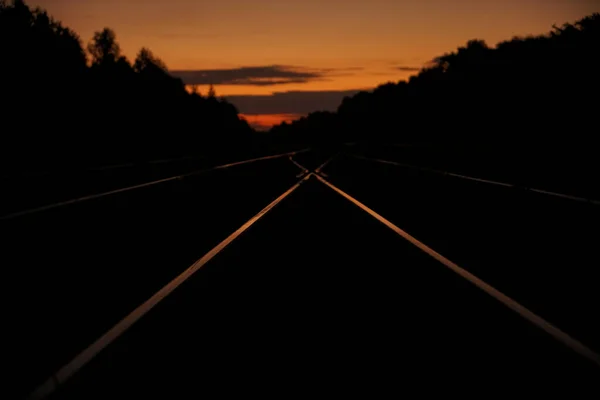 노을에 하늘과 배경에 대항하는 움직임 효과를 철도역 철도가 허물어지다 — 스톡 사진